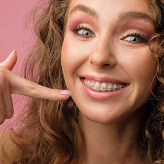 a patient with braces smiling brightly 