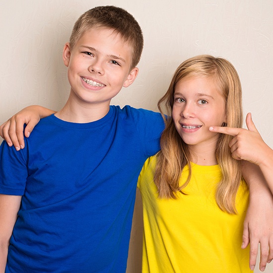 Boy and girl with dentofacial orthopedics smiling