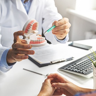 Derry orthodontist pointing to model of teeth