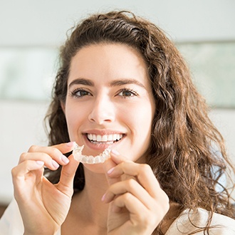 Woman placing her Invisalign tray