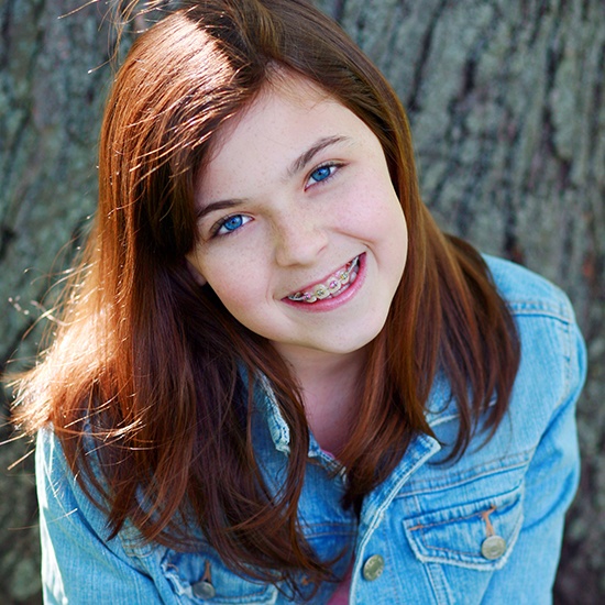 Young girl with traditional braces smiling