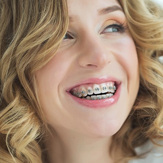 Smiling young woman with traditional braces