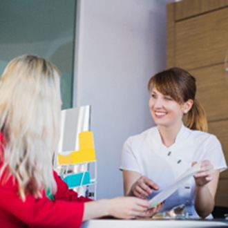 Smiling orthodontic assistant showing patient financial options