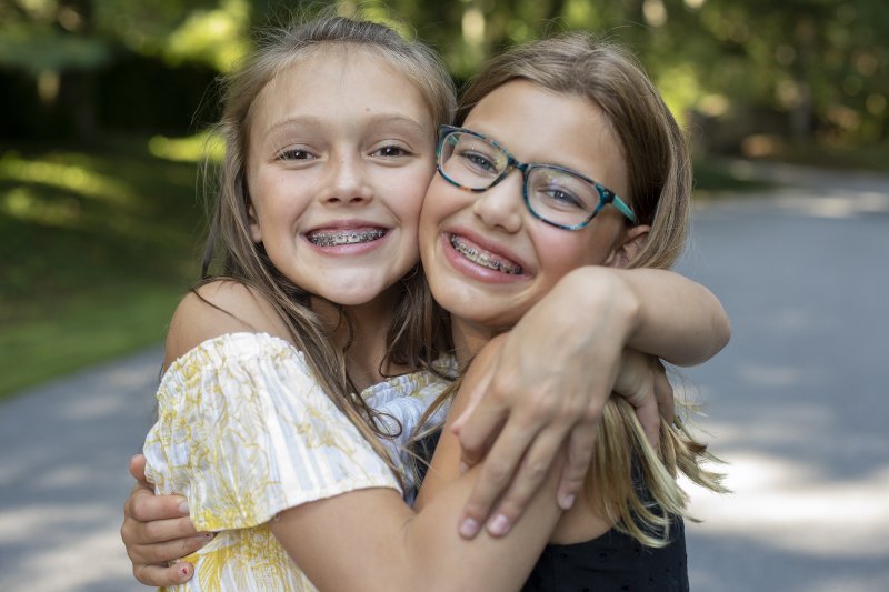 Two girls hugging and smiling with braces