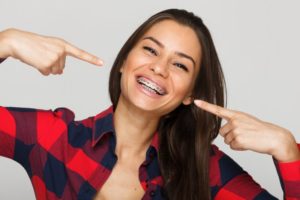 Smiling woman points to her braces in Derry