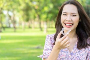 Smiling woman wearing Invisalign in Derry outside