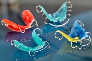 several colorful retainers on a plain background
