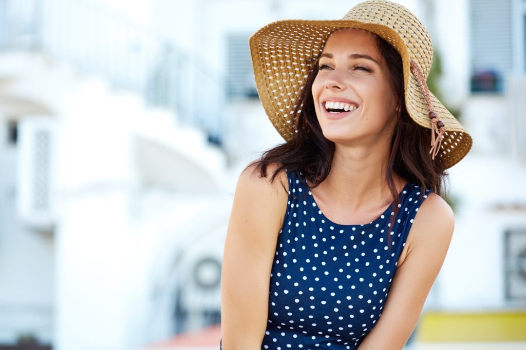 Woman in sun hat smiling while enjoying weather
