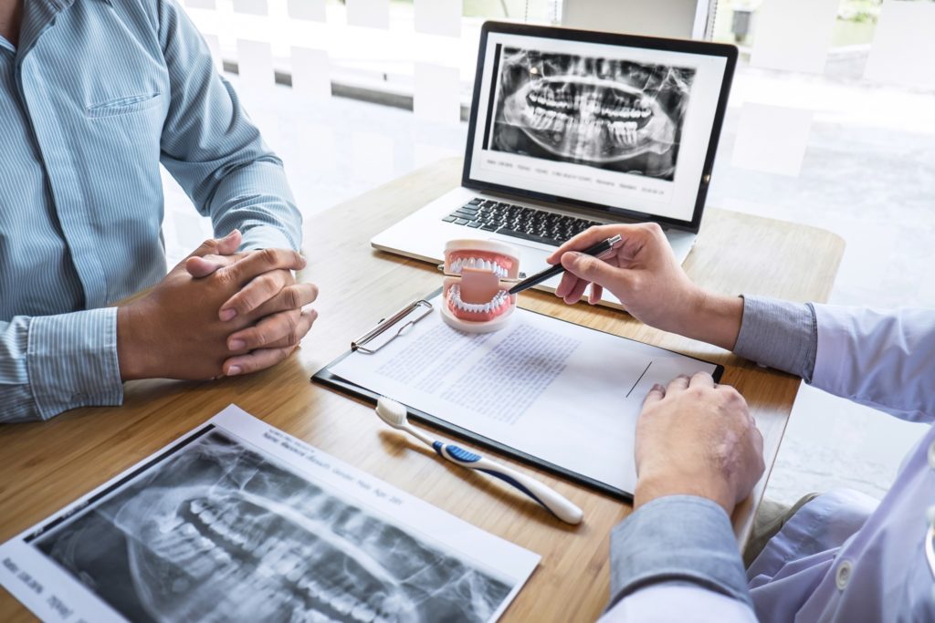 Orthodontist pointing to model of teeth