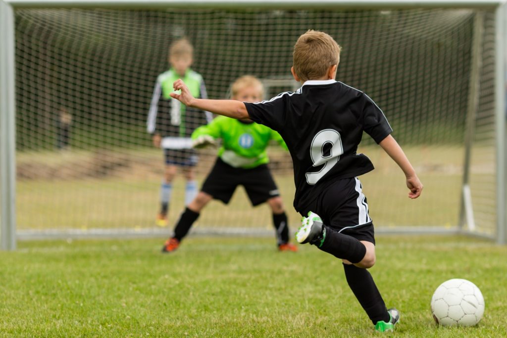 Child kicking soccer ball