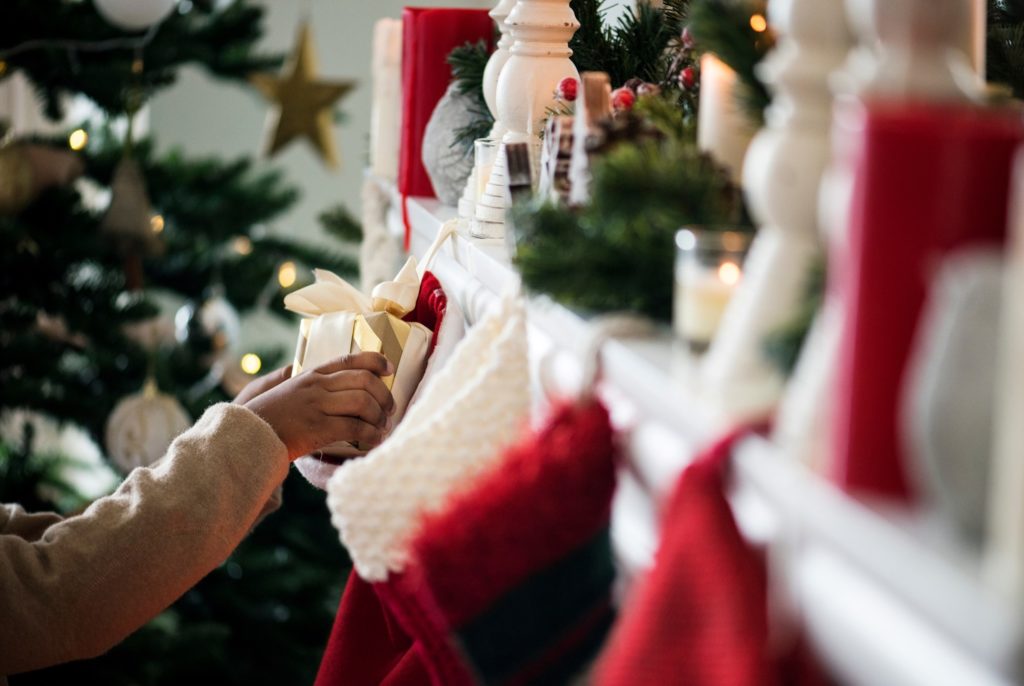 Closeup of child grabbing gift from stocking on fireplace