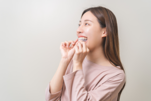 a close-up of a patient removing their Invisalign tray